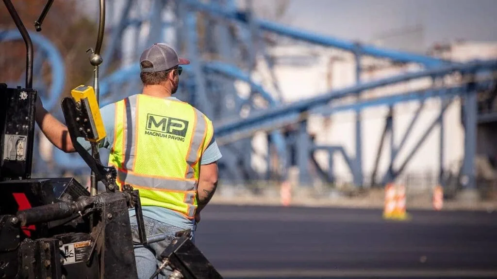 magnum paving employee riding on a truck