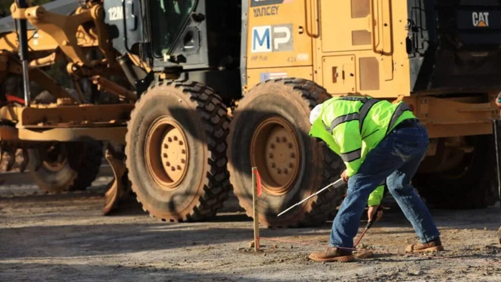 magnum paving employee digging into the ground