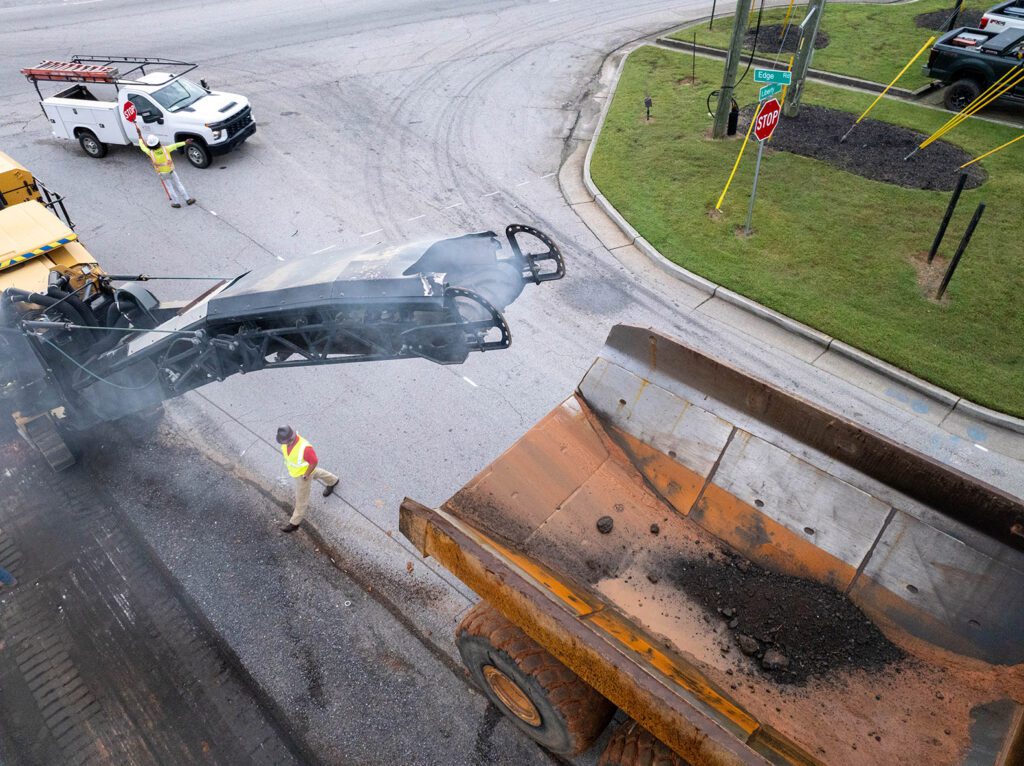 asphalt milling cold planer and a dump truck